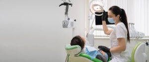 Caucasian woman dentist doctor in office with dental equipment microscope treats teeth to patient in chair. Place for your text. Medicine and dentistry concept.